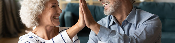 Excited older couple giving high five, celebrating good news