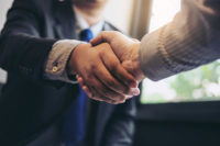 shaking hands during a meeting to sign agreement